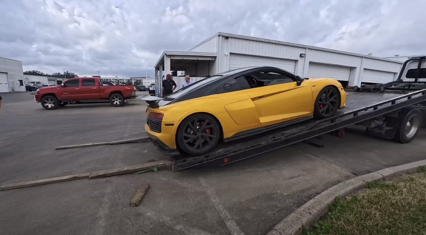 Yellow luxury sports car on flatbed tow truck showing safe transport method